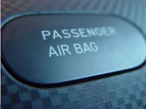 Close up of a button on a car console labeled "Passenger Air Bag"