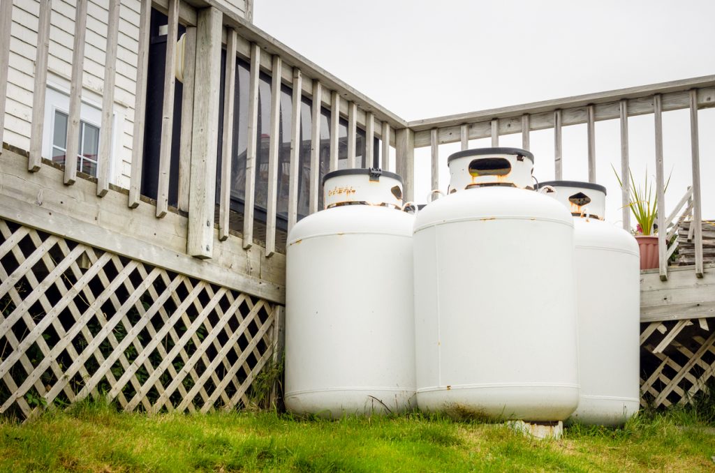 Group of propane cylinders in the backyard of a house