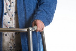 elderly person using a walker with a blue robe on. 