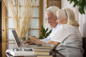 Two edelry people looking at computer