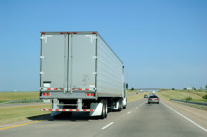 A semi truck driving down a highway. 