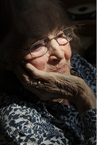 older woman with her hand against her face