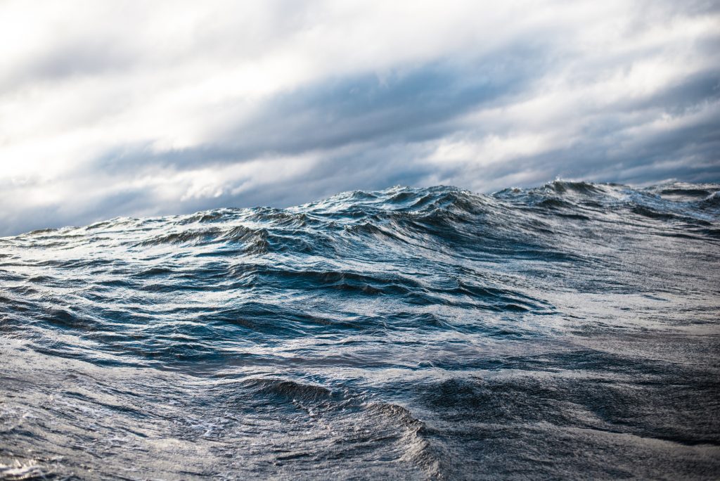 Cold blue sea at sunset. waves and clouds