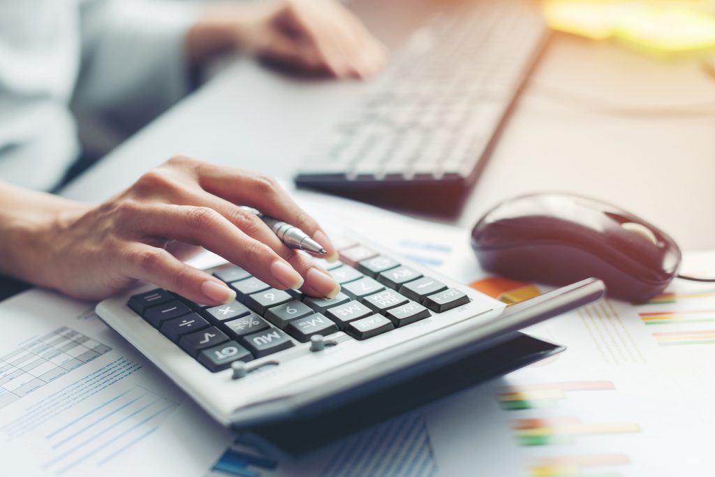 Person using a calculator and computer