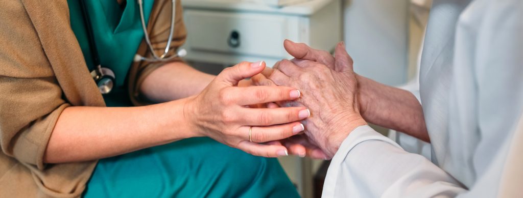 doctor holding an elderly woman's hands