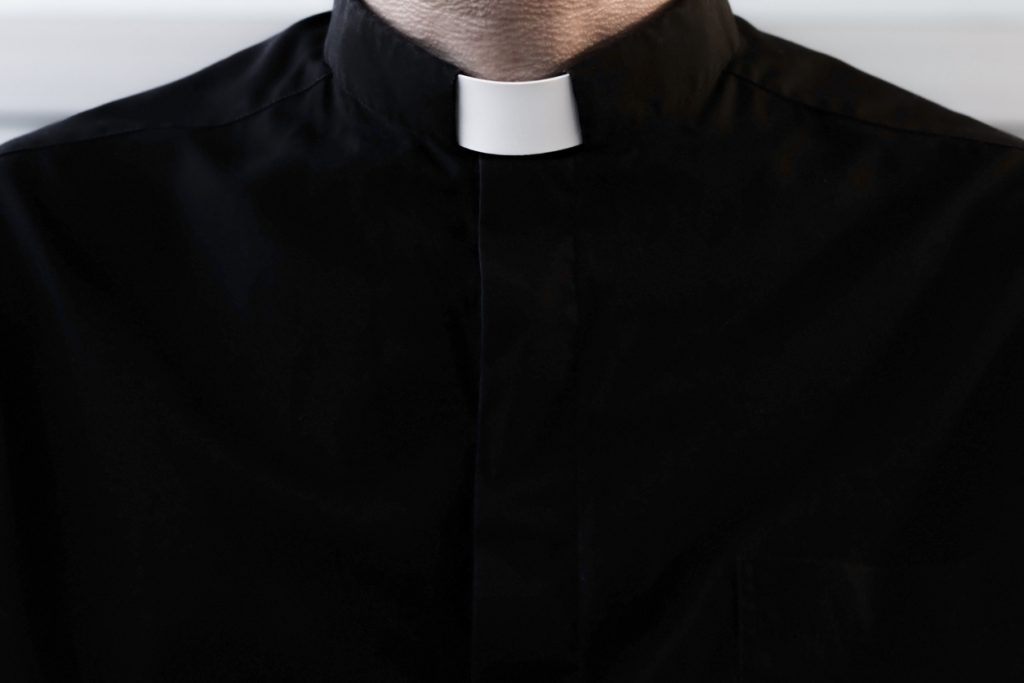 A silhouette of a Catholic priest