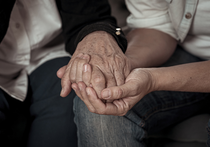 Elderly hand being held by another hand 